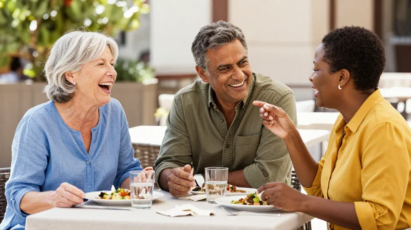 Group of adults over 50 laughing together at an outdoor lunch, showing social connection in over 50 dating life